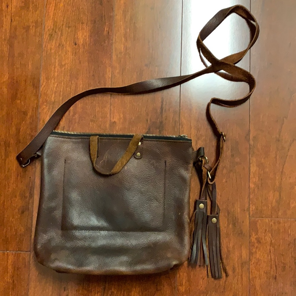 100% leather messenger style purse w/ tassels. Natural ware. Great shape!